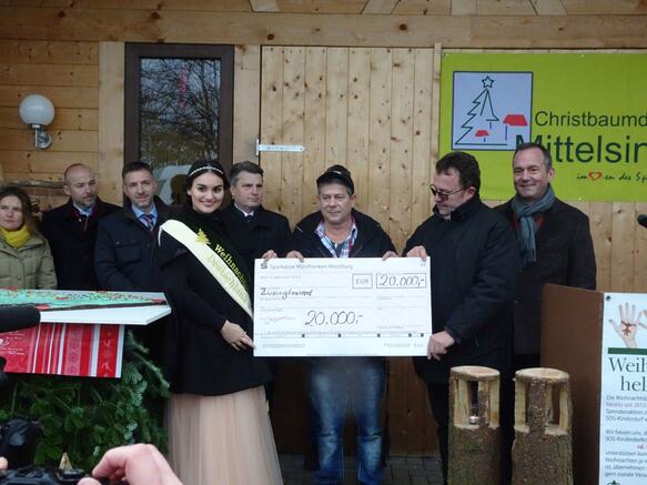 Die Deutsche Weihnachtsbaumkönigin, Vanessa Frank und Bernd Oelkers, Vorsitzender des Bundesverbandes der Weihnachtsbaum- und Schnittgrünerzeuger überreichen SOS-Kinderdorfbotschafter Michael Hirte (Mitte) eine Spende. 